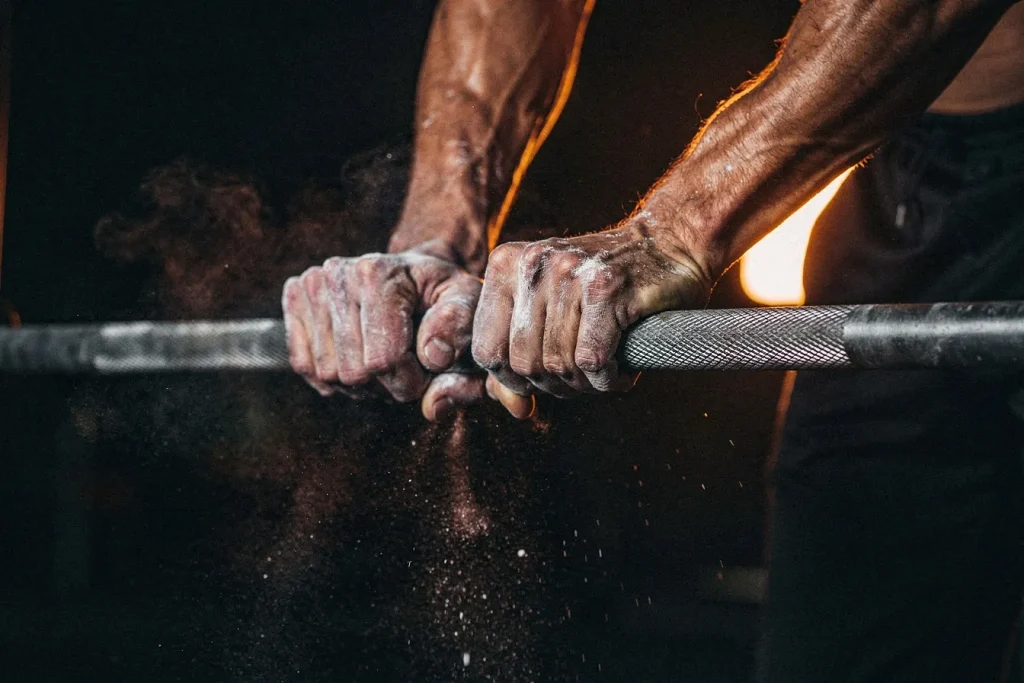 Chalked hands gripping a pull-up bar before a set of pull-ups